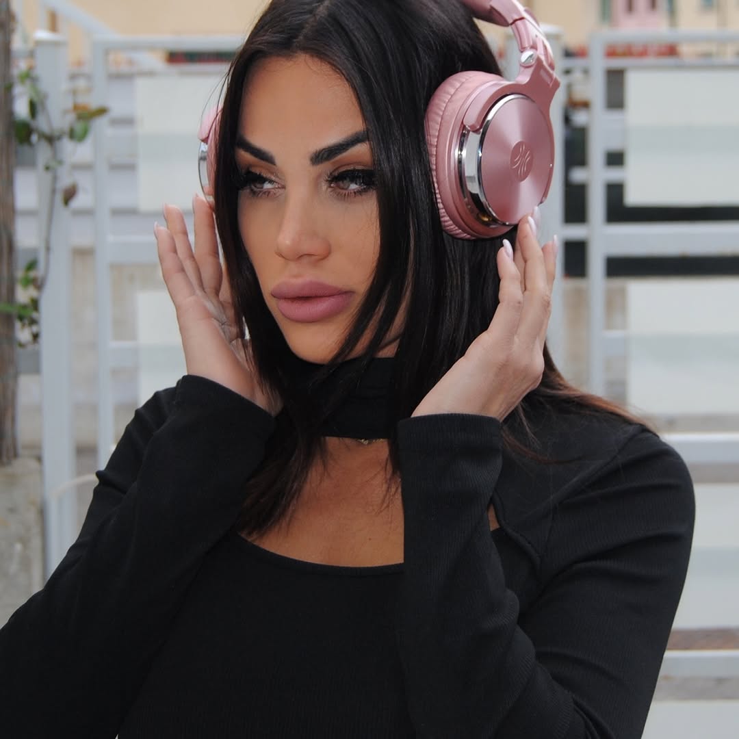 DJ Joy Giovy con cuffie a un evento, luce di giorno